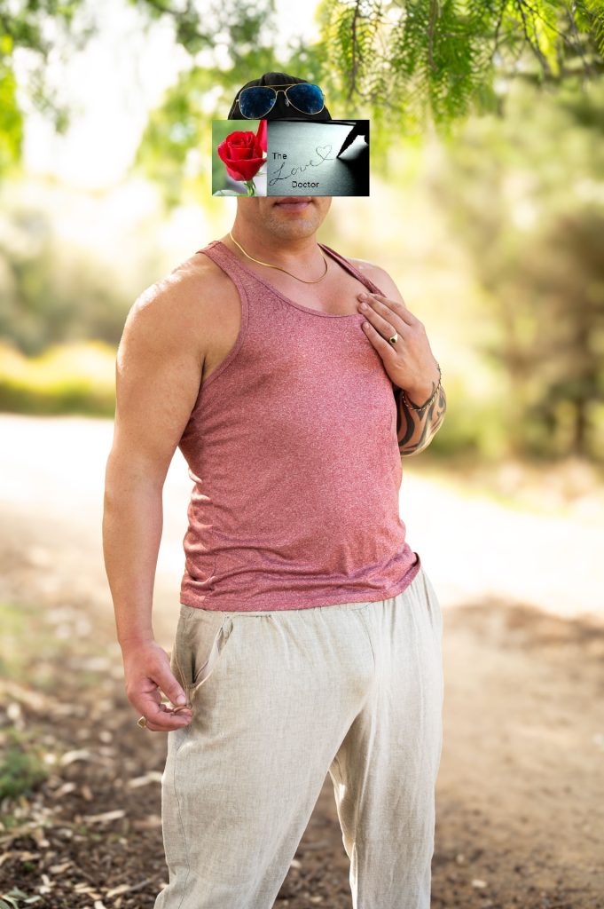 Man in tank top and linen pants, with a rose and 