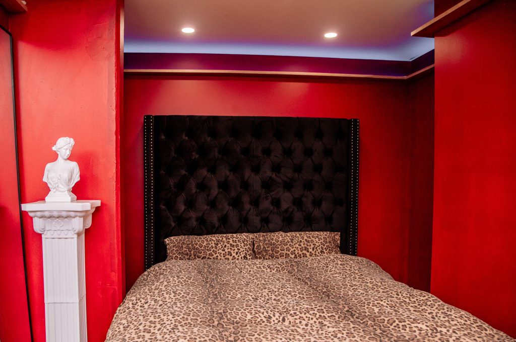 Luxurious red bedroom with a tufted headboard and leopard print bedding