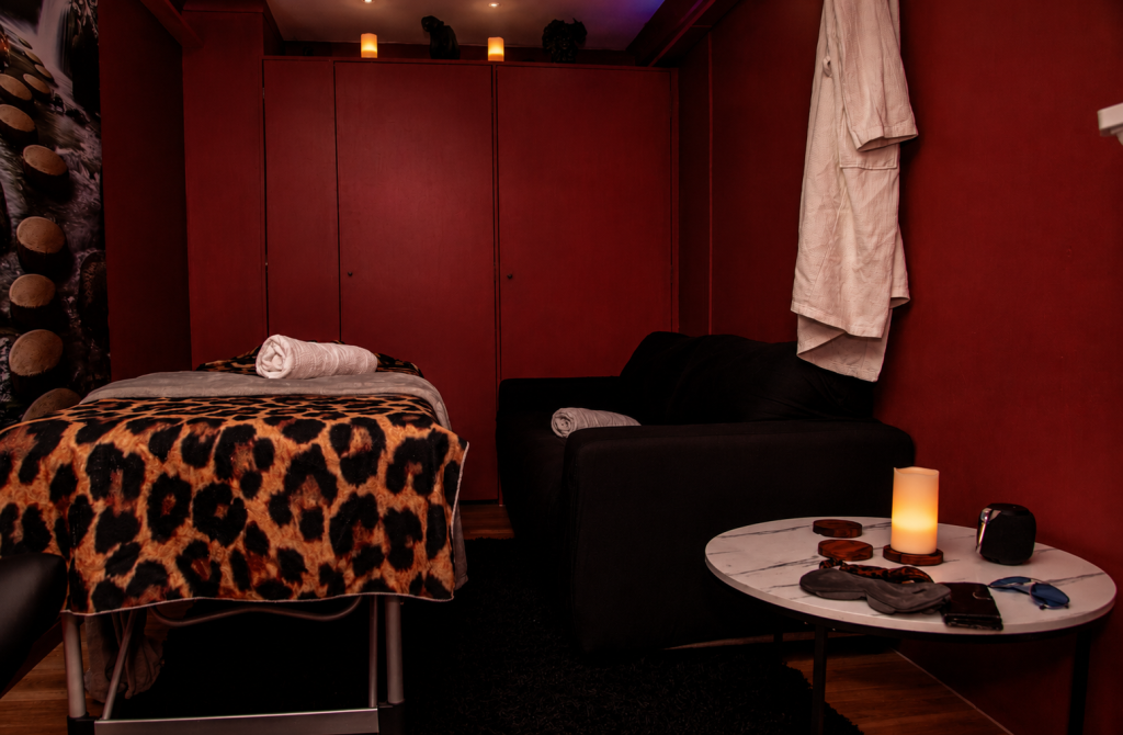 Massage room with leopard print table, black armchair, and spa ambiance