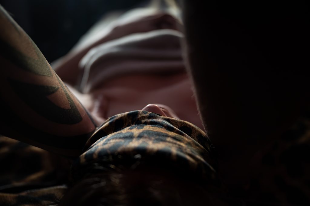 Close up of a person's face with a leopard print blindfold, July 2026 gallery.