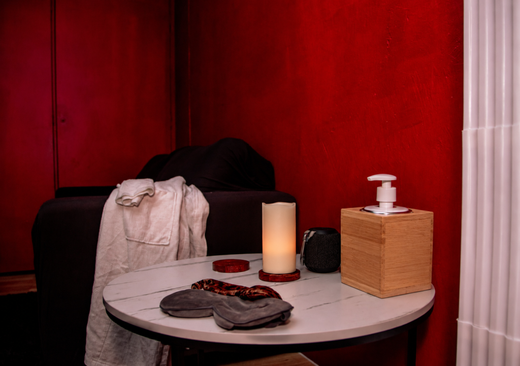 Spa room with massage table, robe, slippers, and candle
