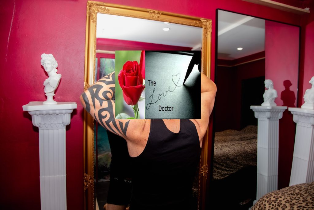 Man with tattoos reflected in a mirror with a rose and 