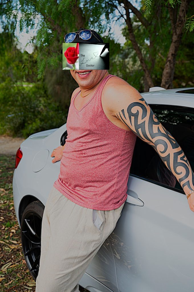 Man with arm tattoo leaning on white car, 