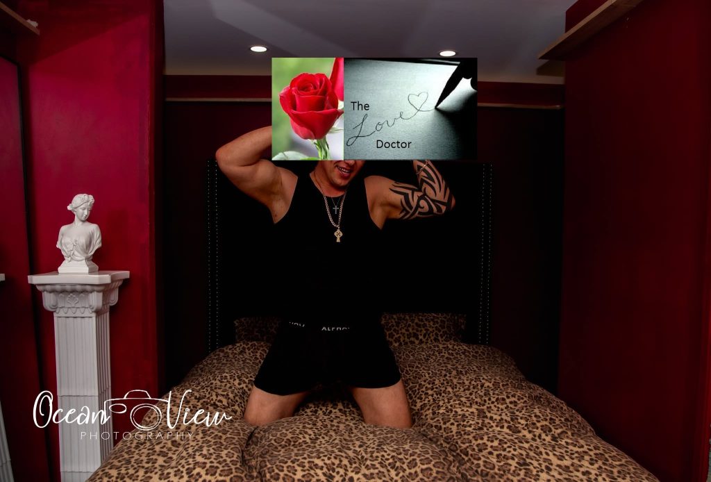 Man in black tank top and boxers on a leopard print bed, with a rose and 