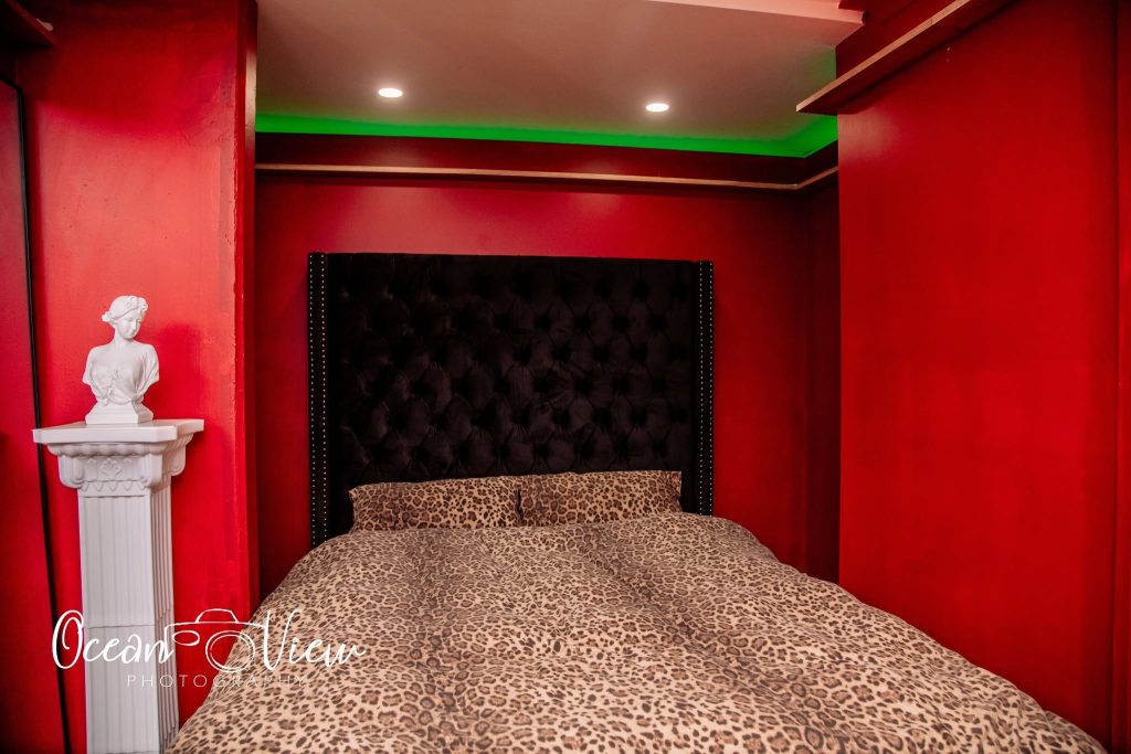 Luxurious massage studio bedroom with a tufted headboard and leopard print bedding.